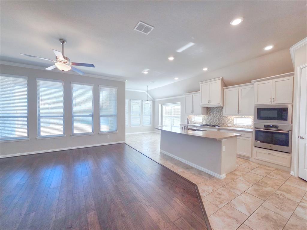 355 Prairie Ridge Lane Lewisville, TX 75056 - Photo 6 of 24 a large kitchen with cabinets wooden floor and stainless steel appliances