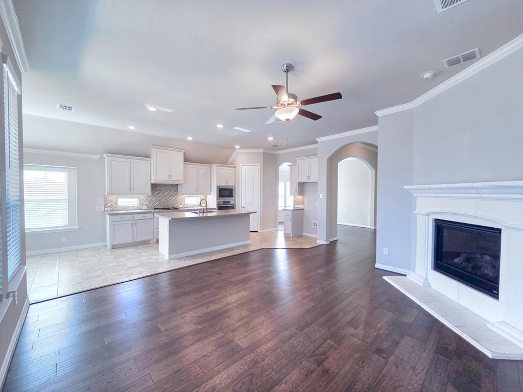 355 Prairie Ridge Lane Lewisville, TX 75056 - Photo 7 of 24 a view of an empty room and kitchen with fireplace wooden floor