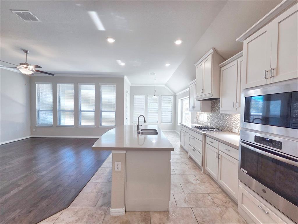 355 Prairie Ridge Lane Lewisville, TX 75056 - Photo 10 of 24 a large kitchen with stainless steel appliances granite countertop a lot of counter space and wooden floor