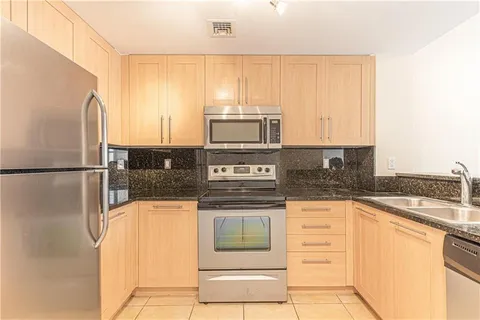 a kitchen with stainless steel appliances granite countertop a stove a sink and a microwave