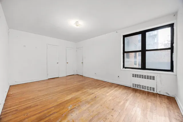 a view of an empty room with wooden floor
