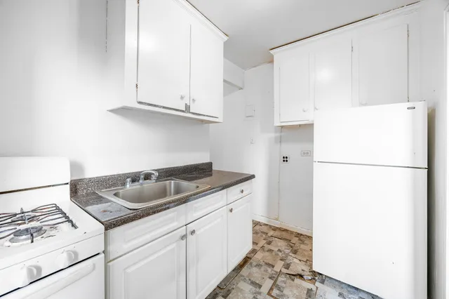 a bathroom with a white bath tub sitting next to a white sink and a shower