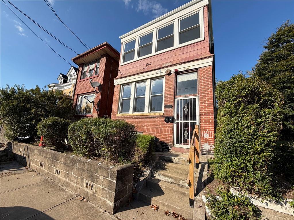 a front view of a house with a garden