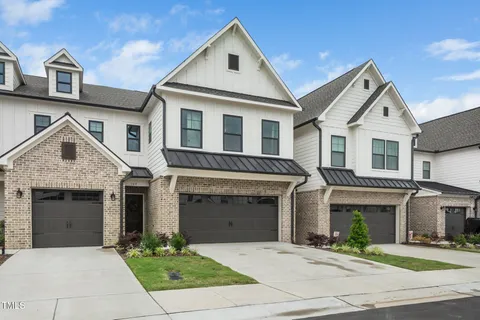 a front view of a house with yard and parking