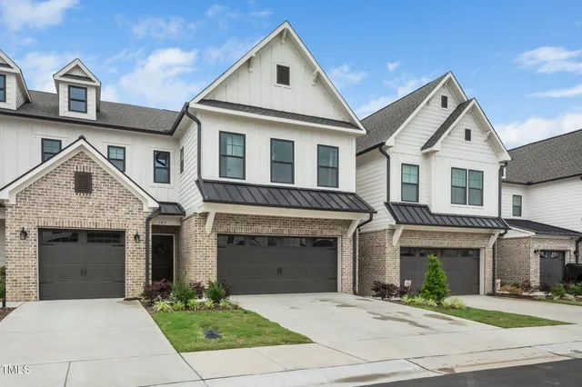 a front view of a house with yard and parking
