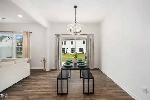 a dining room with furniture a chandelier and wooden floor