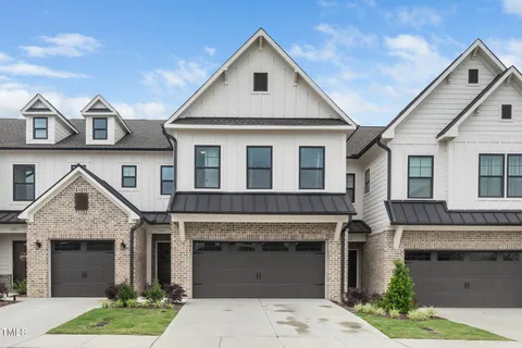 a front view of a house with a garden and garage