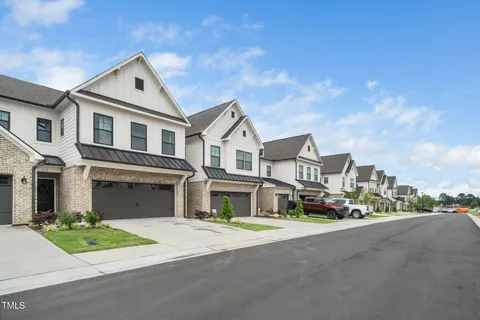 a front view of a house with a garden and plants