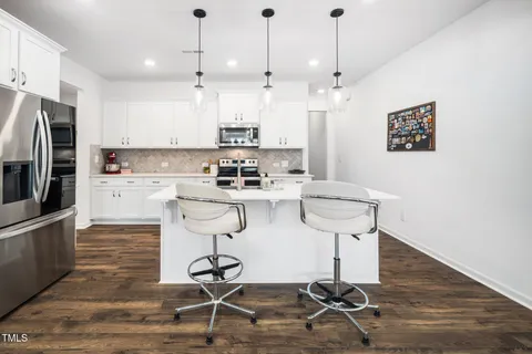 a kitchen with stainless steel appliances granite countertop a sink a stove a refrigerator and cabinets