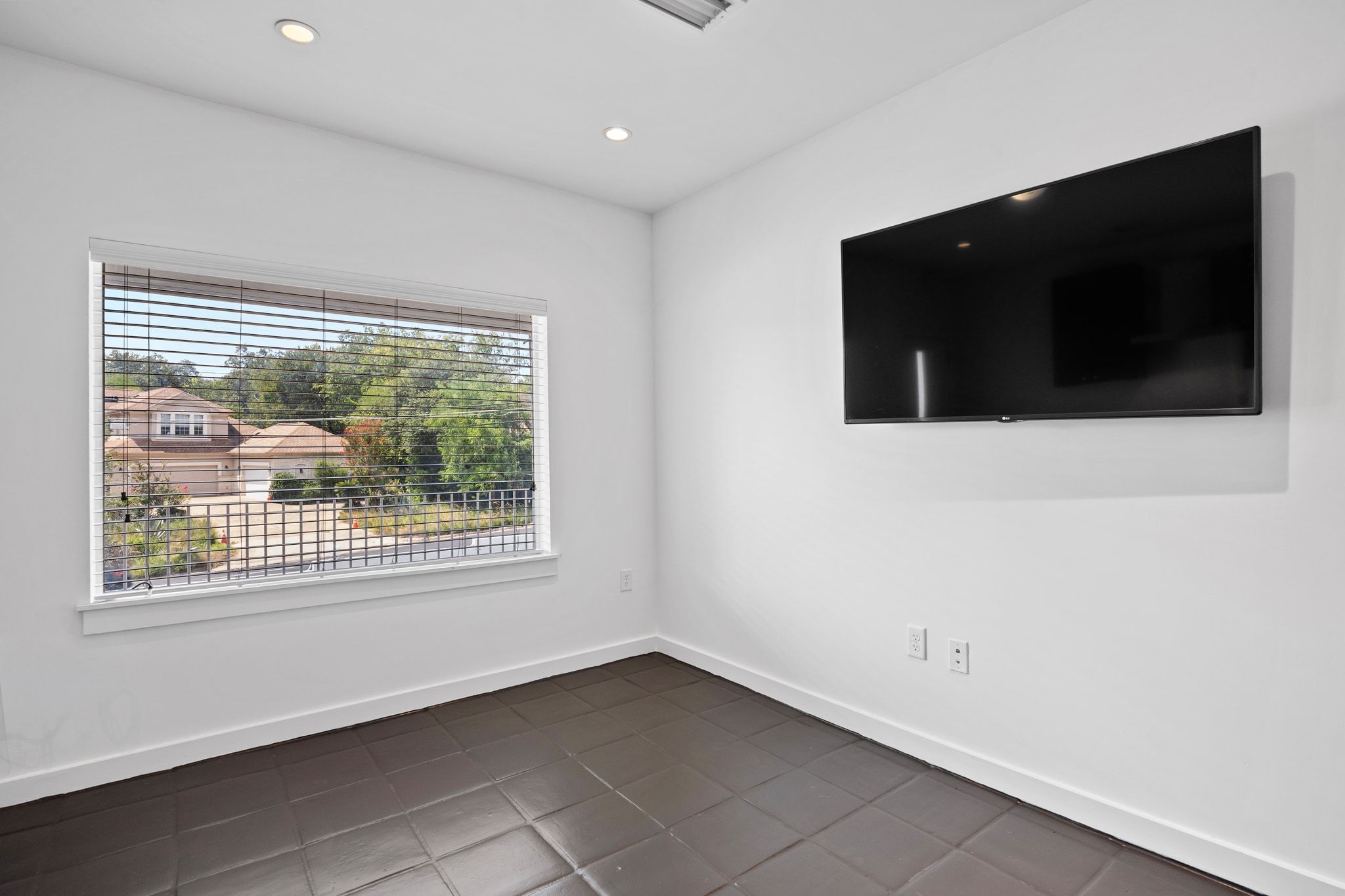 1200 Enfield Road, Unit 205 Austin, TX 78703 - Photo 6 of 20 a view of an empty room with a tv and a window