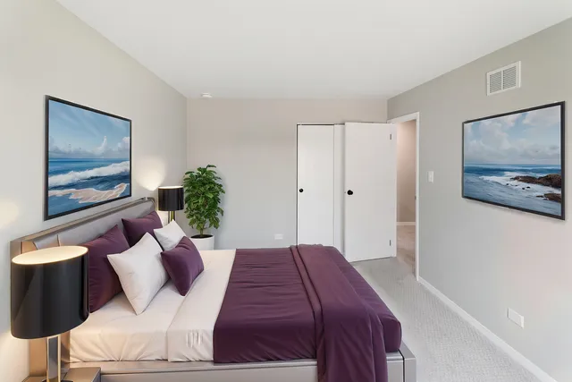 a bedroom with a large bed and a painting on the wall