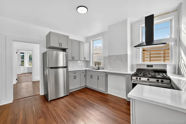 a kitchen with wooden floors and white appliances