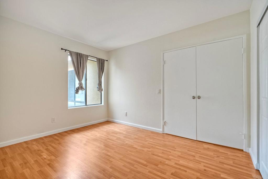2251 Altisma Way, Unit 202 Carlsbad, CA 92009 - Photo 12 of 35 a view of an empty room with wooden floor and a window