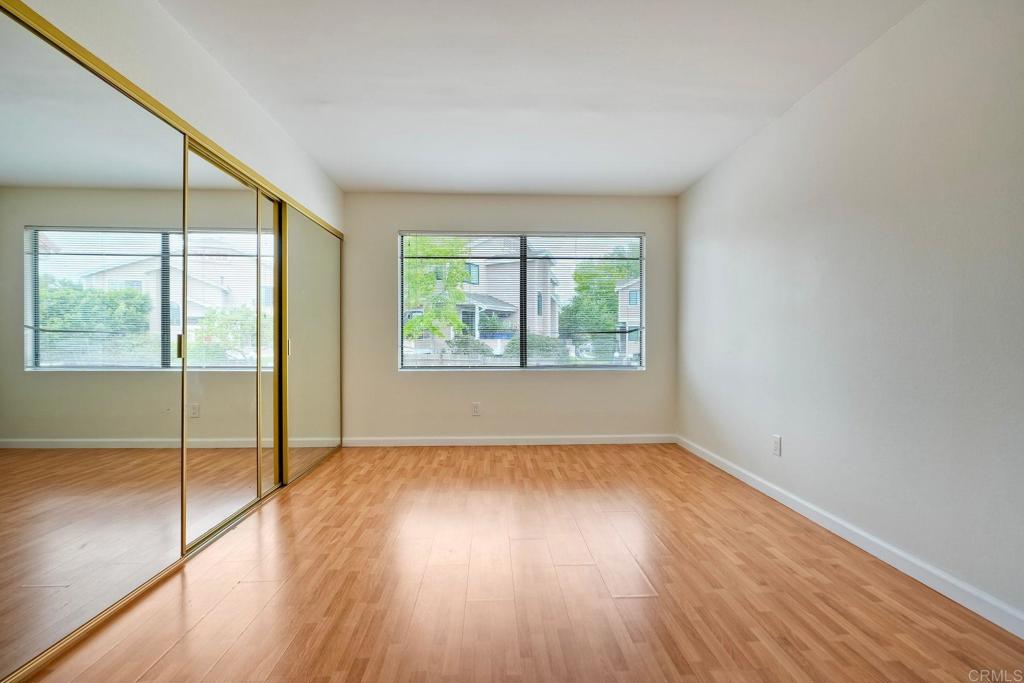 2251 Altisma Way, Unit 202 Carlsbad, CA 92009 - Photo 14 of 35 an empty room with wooden floor and windows