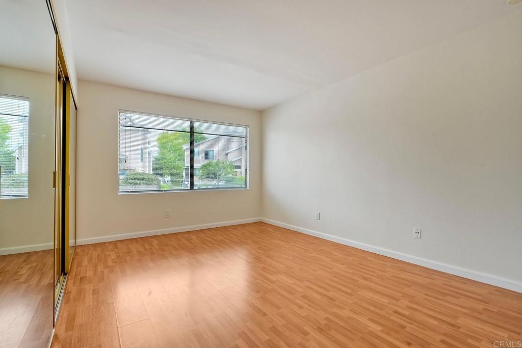2251 Altisma Way, Unit 202 Carlsbad, CA 92009 - Photo 15 of 35 an empty room with wooden floor and windows