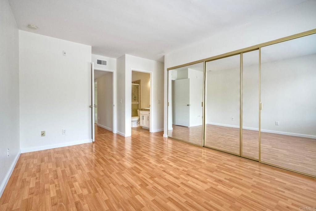 2251 Altisma Way, Unit 202 Carlsbad, CA 92009 - Photo 16 of 35 a view of an empty room with wooden floor and a window