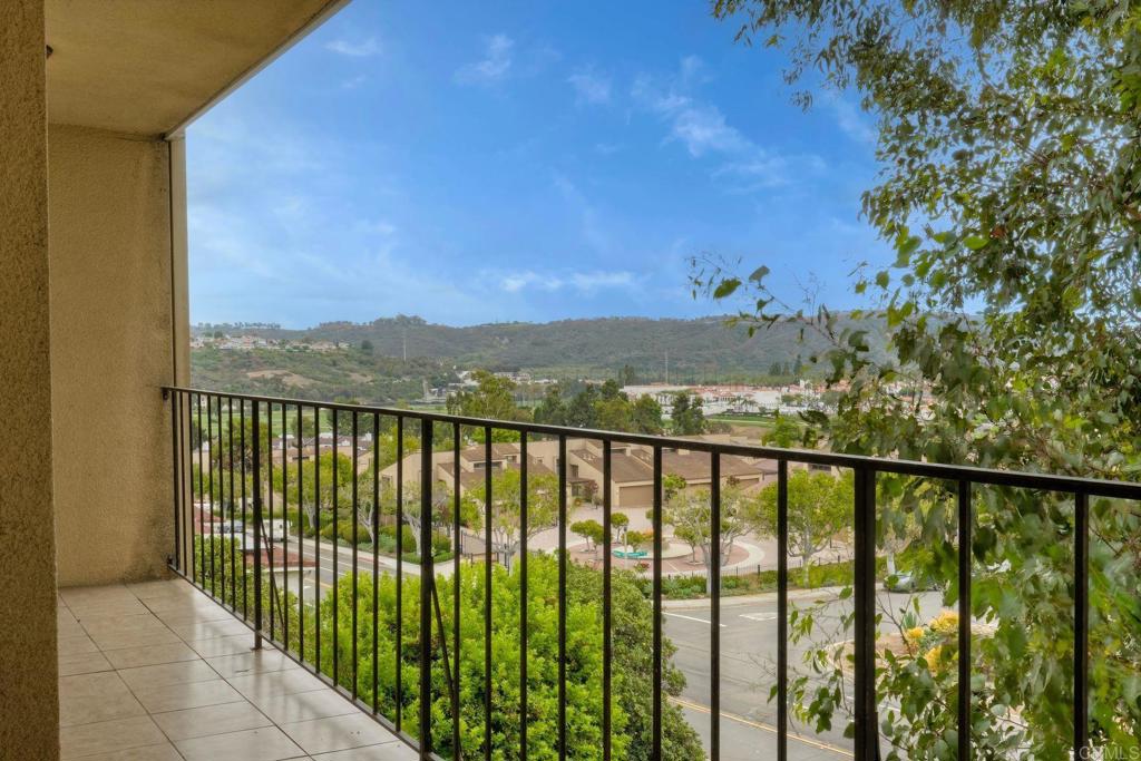 2251 Altisma Way, Unit 202 Carlsbad, CA 92009 - Photo 2 of 35 a view of a balcony with wooden fence and floor