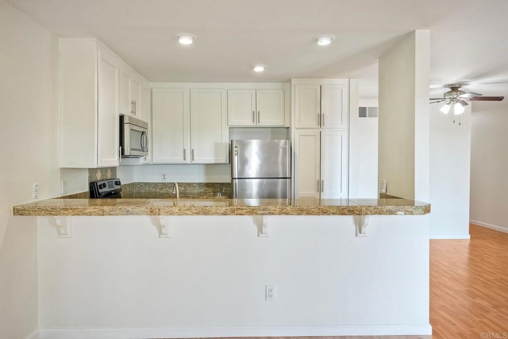 2251 Altisma Way, Unit 202 Carlsbad, CA 92009 - Photo 23 of 35 a kitchen with stainless steel appliances granite countertop a sink and a refrigerator