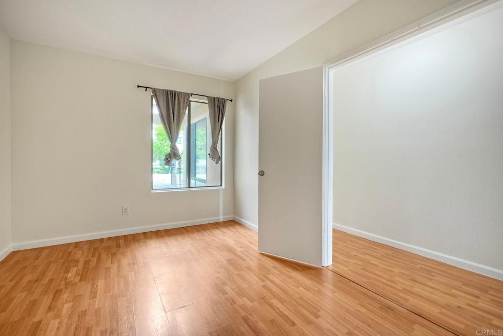 2251 Altisma Way, Unit 202 Carlsbad, CA 92009 - Photo 26 of 35 a view of an empty room with wooden floor and a window