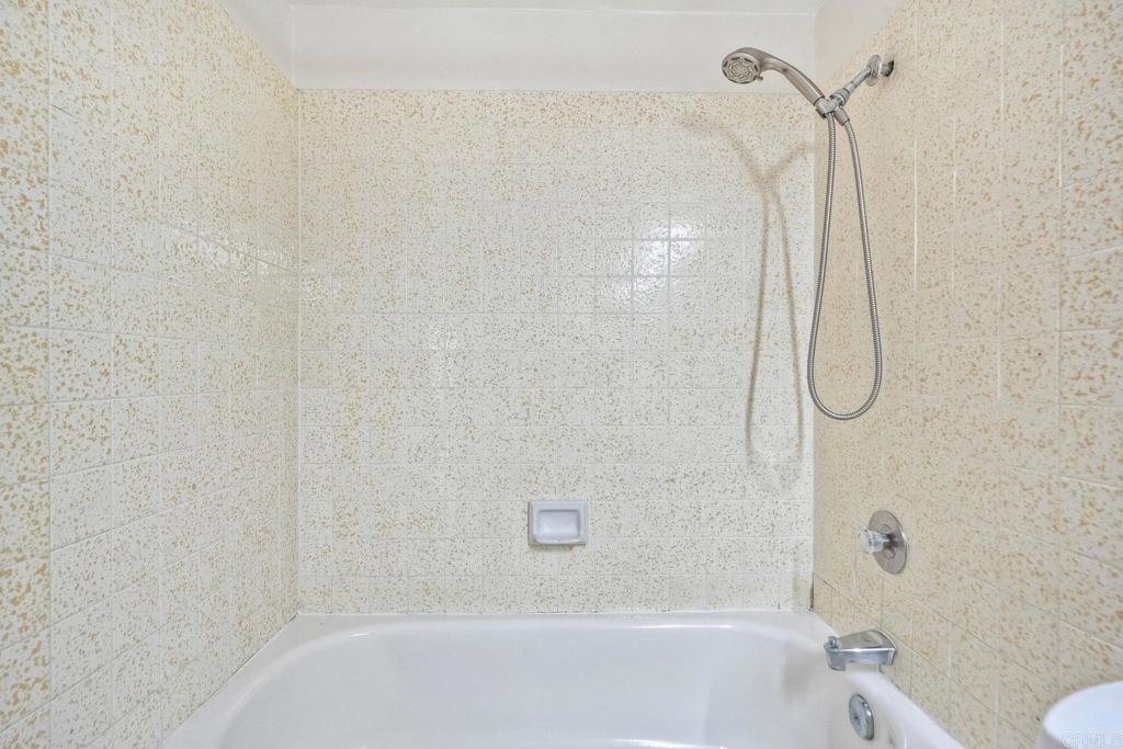 2251 Altisma Way, Unit 202 Carlsbad, CA 92009 - Photo 27 of 35 a bathroom with a bath tub with a shower