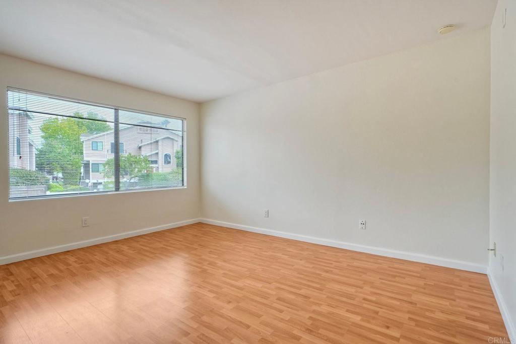 2251 Altisma Way, Unit 202 Carlsbad, CA 92009 - Photo 29 of 35 a view of an empty room with wooden floor and a window