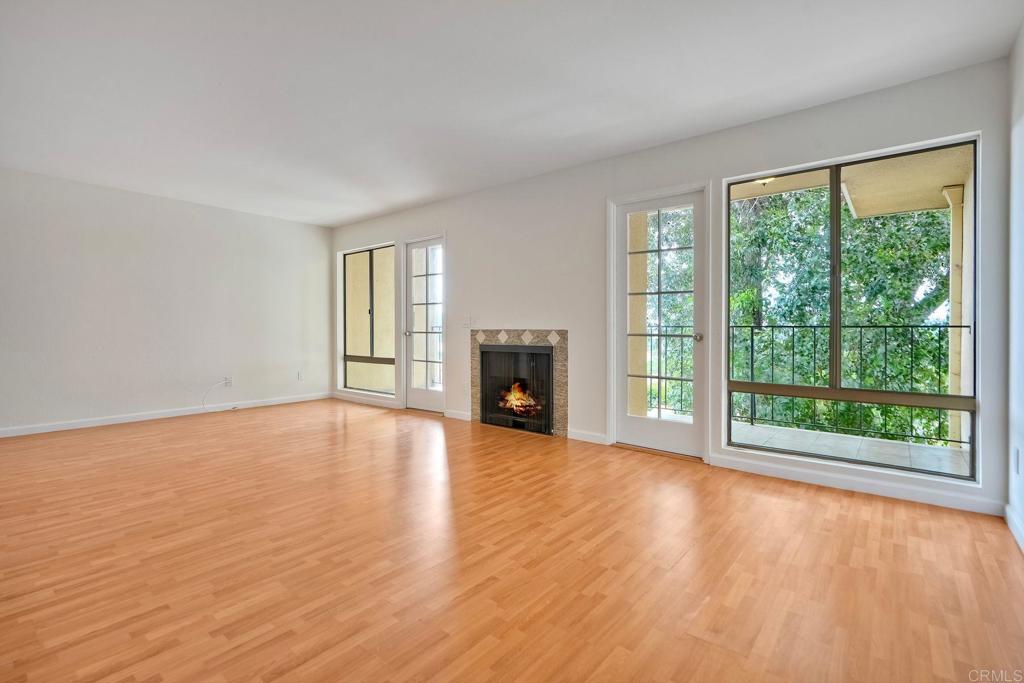2251 Altisma Way, Unit 202 Carlsbad, CA 92009 - Photo 7 of 35 a view of empty room with wooden floor and fireplace