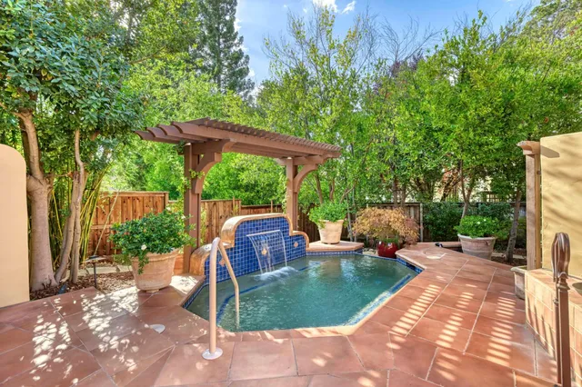 a view of a patio with table and chairs potted plants and large tree