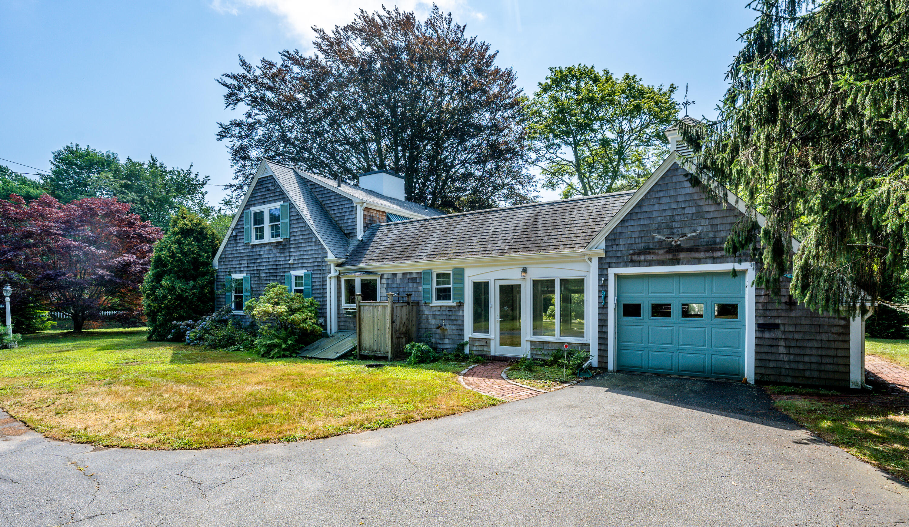 115 Old Stage Road Centerville, MA 02632 - Photo 1 of 32 a front view of a house with a garden and plants