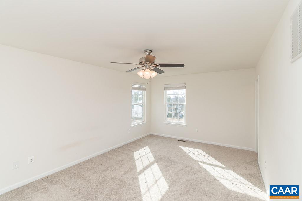 258 Larchmont Circle Ruckersville, VA 22968 - Photo 14 of 40 an empty room with windows and chandelier fan
