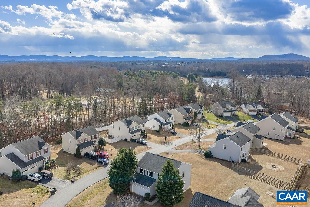 258 Larchmont Circle Ruckersville, VA 22968 - Photo 35 of 40 a view of a lake with couches in the patio