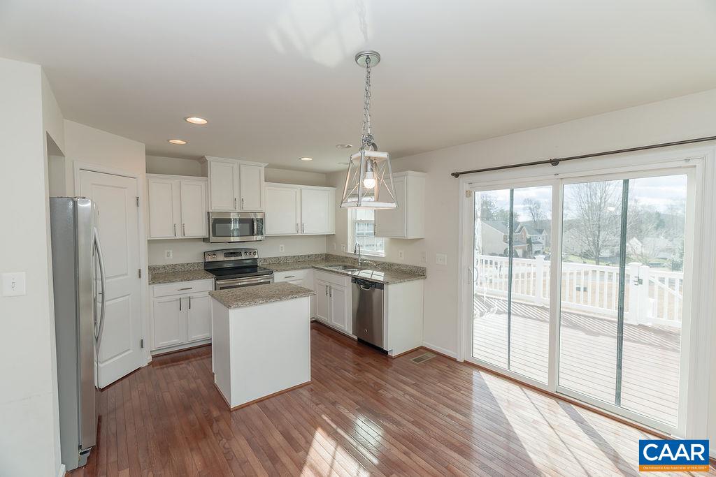 258 Larchmont Circle Ruckersville, VA 22968 - Photo 6 of 40 a kitchen with stainless steel appliances granite countertop a refrigerator a sink dishwasher a stove and white countertops with wooden floor