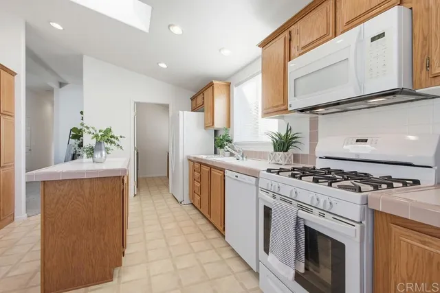 a kitchen with white cabinets and white appliances