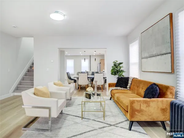 a living room with couches and a potted plant on a dresser