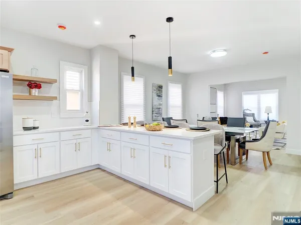 a large white kitchen with lots of counter space sink and appliances