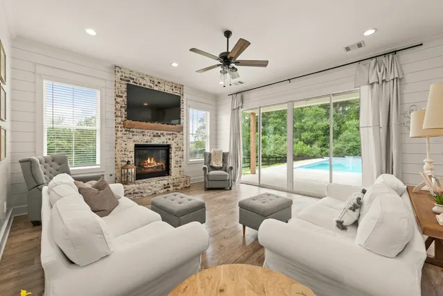 a living room with furniture a fireplace and a flat screen tv