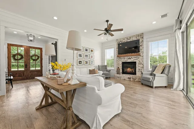 a living room with furniture fireplace and a large window