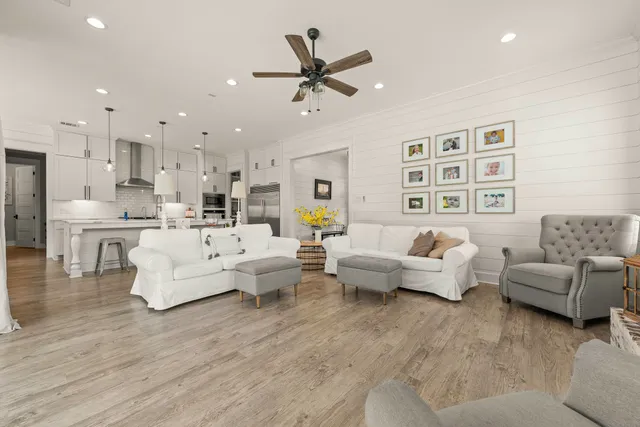 a living room with furniture kitchen view and a chandelier