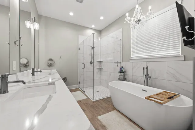 a spacious bathroom with a double vanity sink a mirror and a bathtub