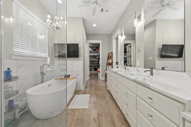 a bathroom with a tub double sink and mirror