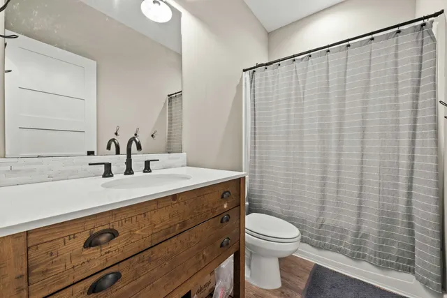 a bathroom with a granite countertop sink a toilet and a mirror