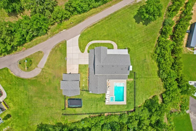 an aerial view of a house with a garden and swimming pool