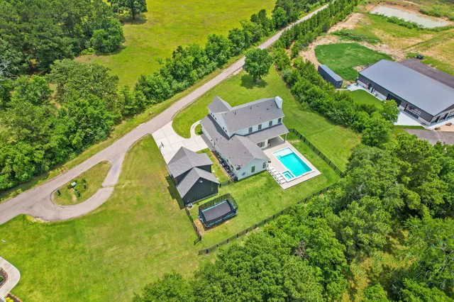an aerial view of a house with a garden and trees