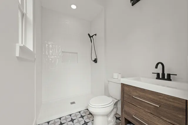 a bathroom with a sink a toilet and shower