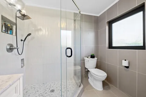 a bathroom with a sink a toilet and shower