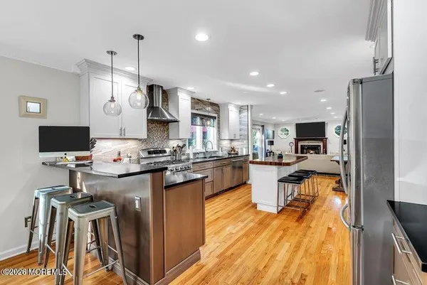 a kitchen with stainless steel appliances granite countertop a sink refrigerator and cabinets