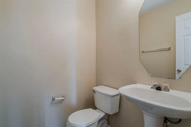 a white toilet sitting next to a bathroom sink