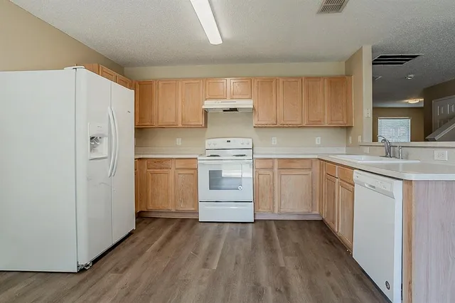 a kitchen with white cabinets and white appliances
