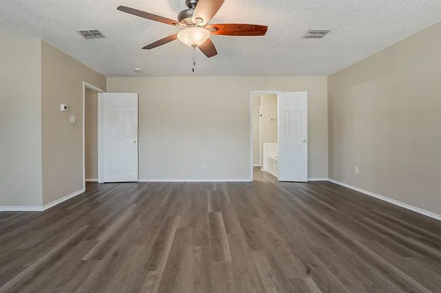 wooden floor in an empty room with a fan