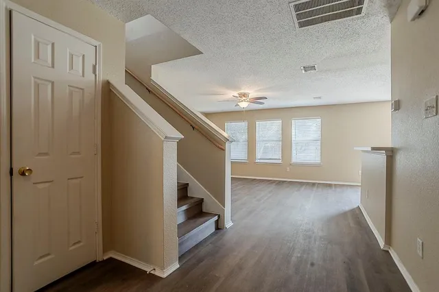 a view of hallway with stairs and wooden floor