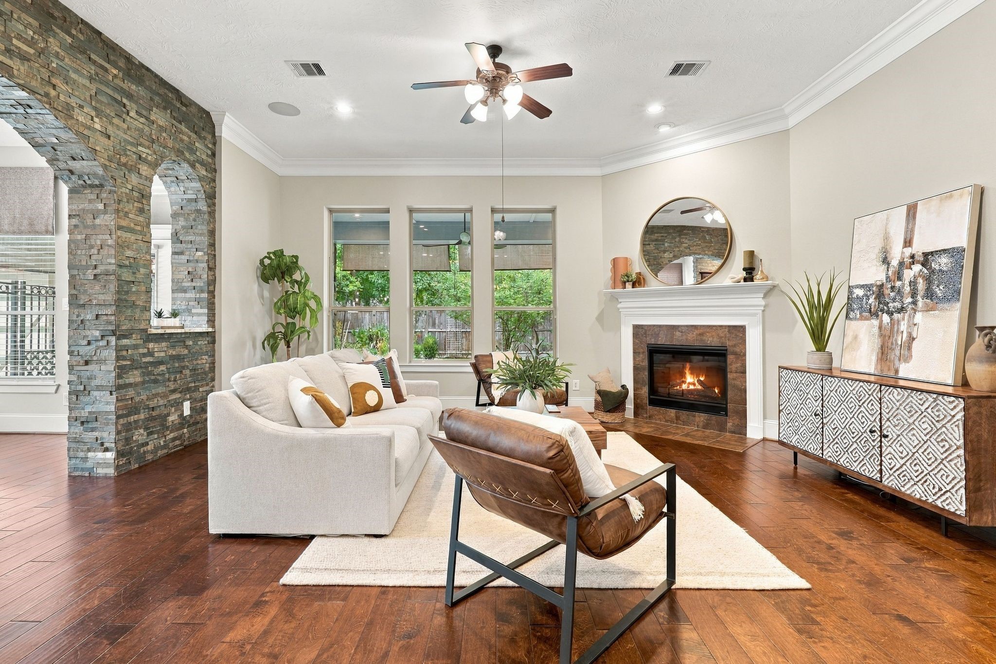 3750 Ribbon Hill Lane Spring, TX 77386 - Photo 8 of 50 Large family room with hardwood floors, gas fireplace and stacked stone accent wall with arched architectural openings adds texture and character.